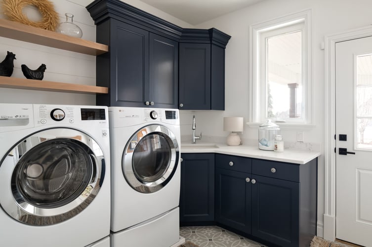 Custom laundry room design featuring white quartz countertops and deep blue cabinets in Utah home by Conner Construction Company