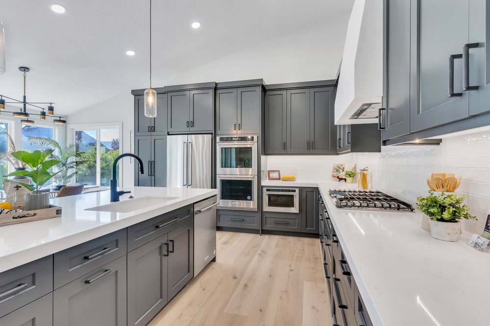Open-concept kitchen with matte black faucet and quartz island by Conner Construction Company in Provo, UT
