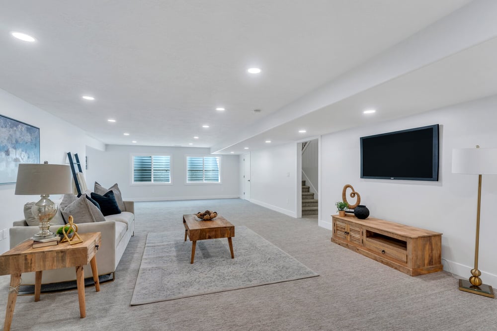 Spacious finished basement with wood furnishings and neutral tones by Conner Construction Company in Pleasant Grove, UT