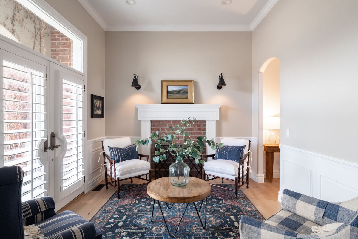 Cozy sitting room with brick fireplace and accent chairs in Highland, UT home by Conner Construction Company