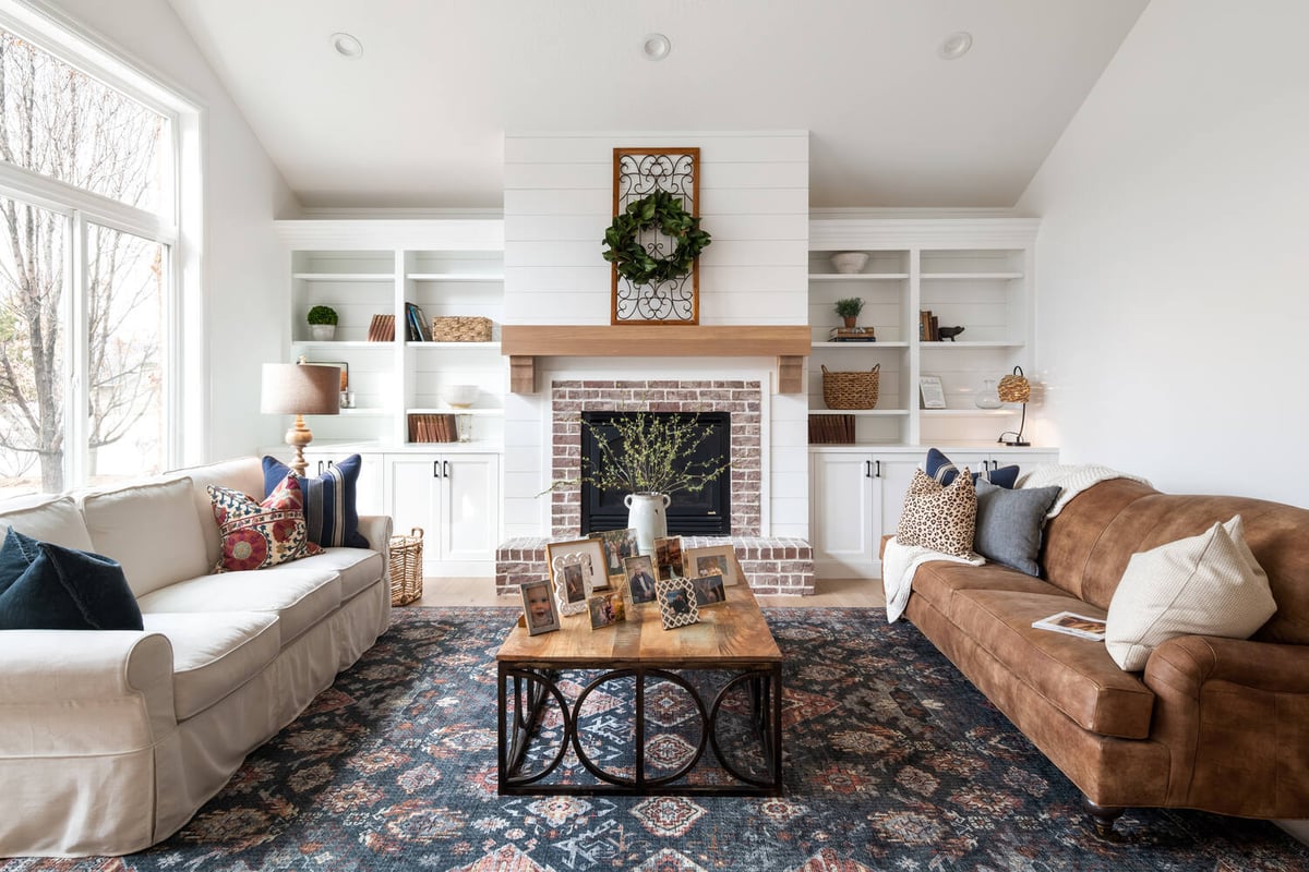 Custom family room in Highland, UT with built-in shelves and white shiplap fireplace by Conner Construction Company