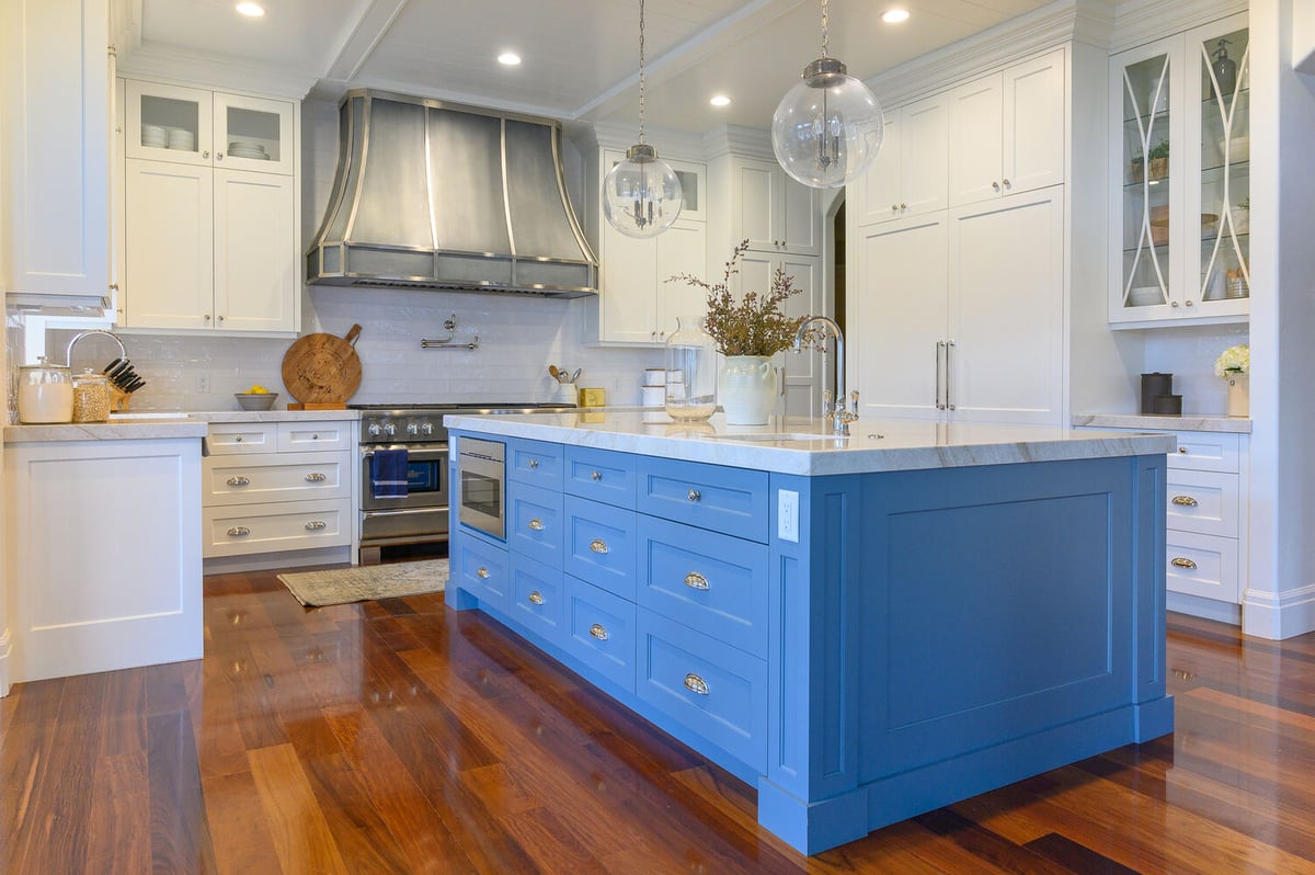 Blue kitchen island with quartz countertops and pendant lighting in a custom kitchen by Conner Construction Company in Eagle Mountain