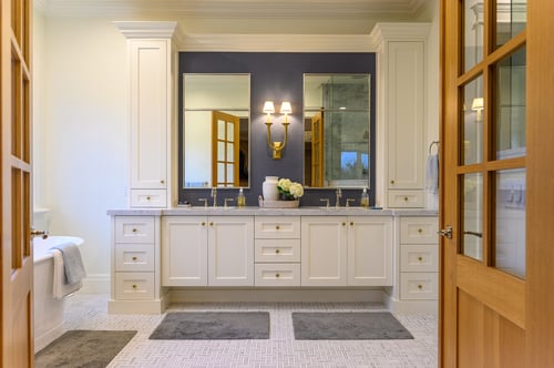 Elegant double vanity with white cabinetry and gold fixtures in a custom home bathroom remodel by Conner Construction Company