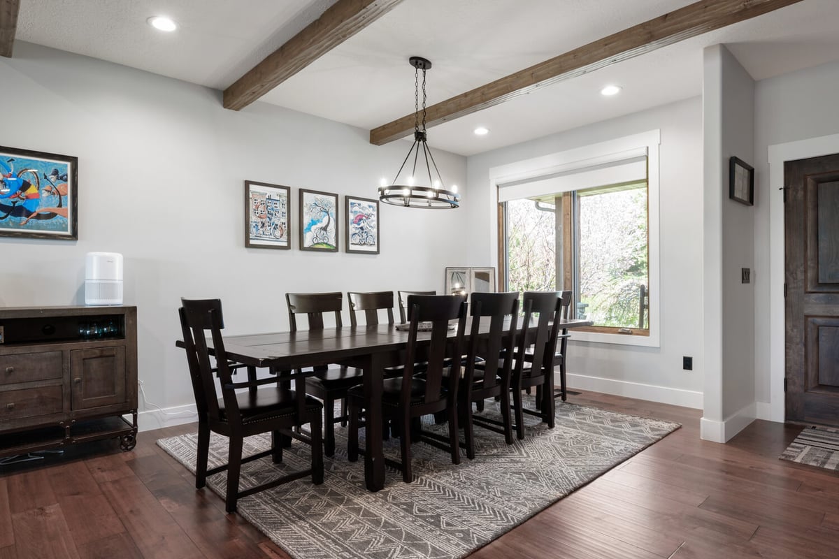 Large custom dining room with wood ceiling beams and 10-seat table by Conner Construction Company in Midway, UT