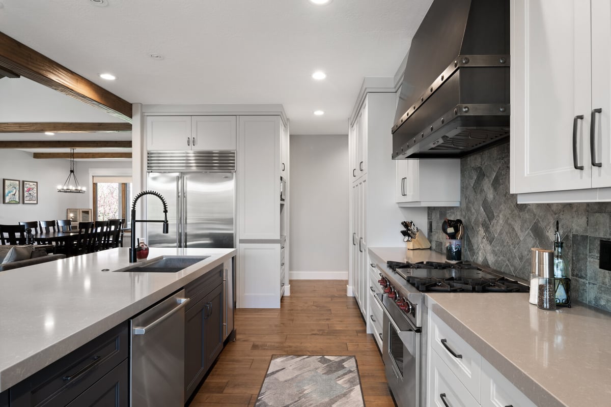 Open kitchen design with dual-tone cabinetry and pro-style range by Conner Construction Company in Alpine, UT