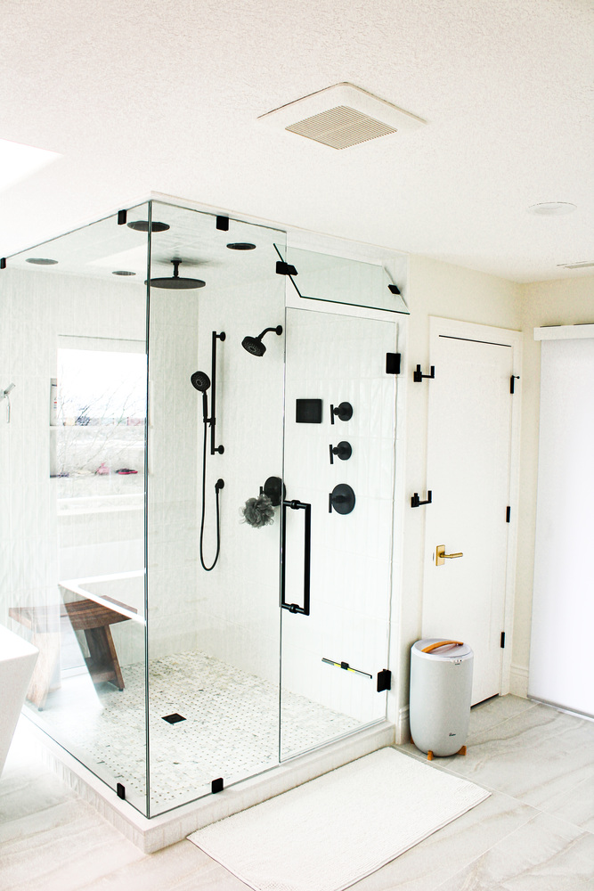 Frameless glass shower with black fixtures in custom home bathroom by Conner Construction Company in Park City, UT