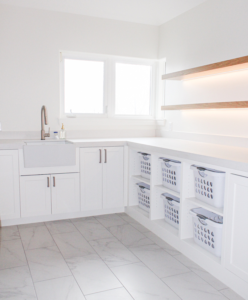 Organized laundry room with sleek countertops and integrated hampers by Conner Construction Company in Utah County
