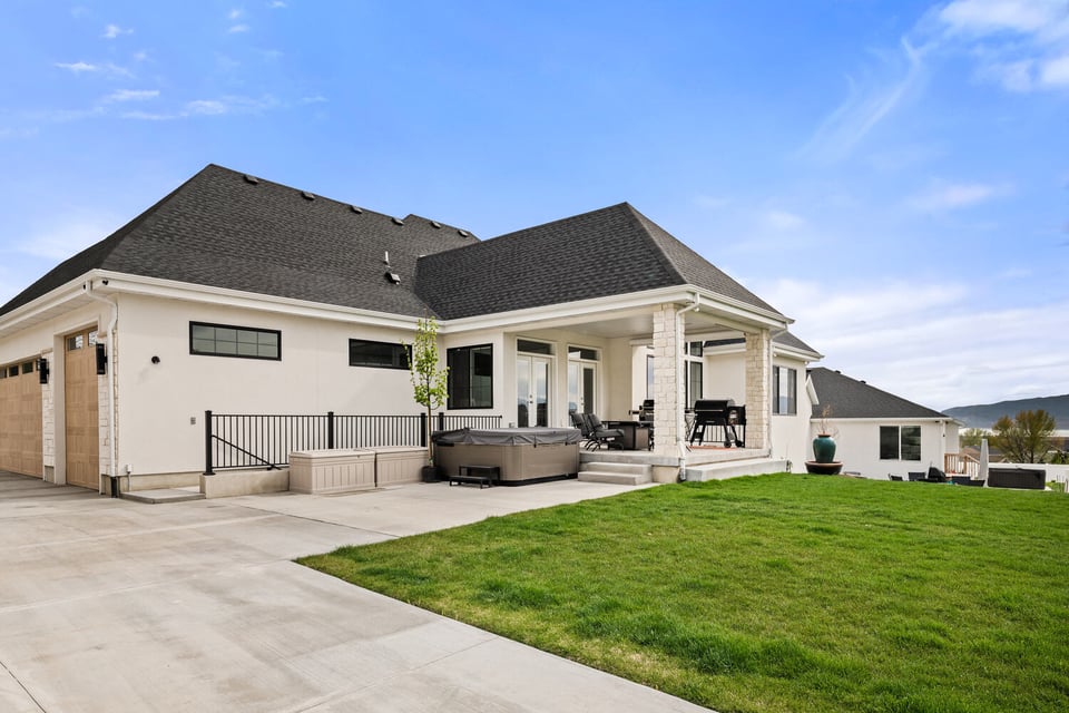 Custom home backyard featuring hot tub and manicured lawn by Conner Construction Company in Pleasant Grove, UT