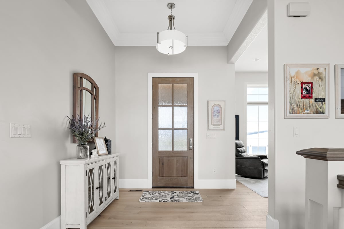 Elegant entryway with wood front door and white trim in Pleasant Grove, UT custom home by Conner Construction Company