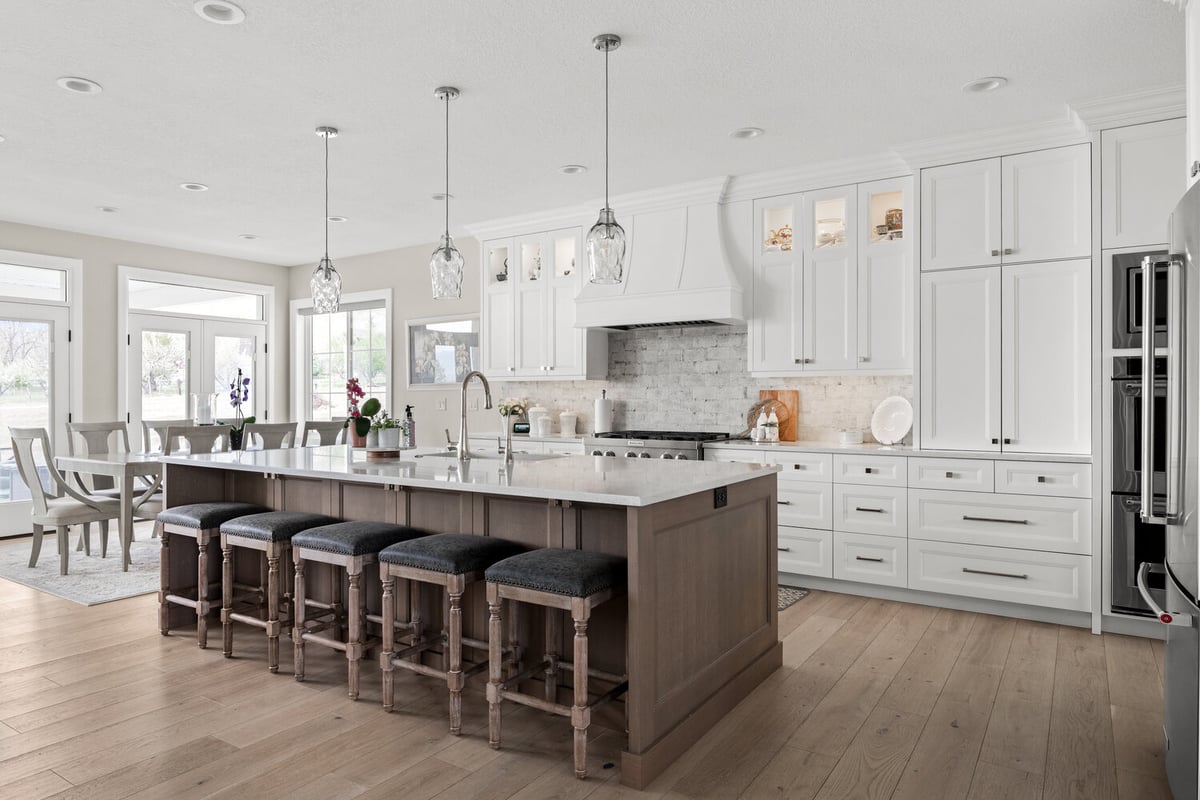Expansive white kitchen with pendant lights and large island in Pleasant Grove custom home by Conner Construction Company