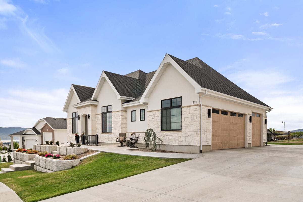 Front exterior view of custom home with stone accents and three-car garage by Conner Construction Company in Pleasant Grove