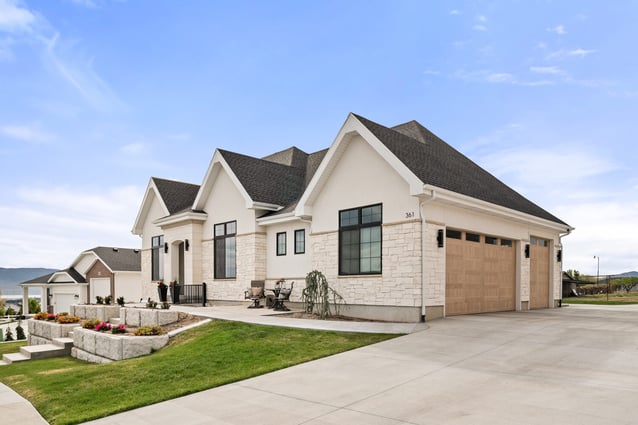 Front exterior view of custom home with stone accents and three-car garage by Conner Construction Company in Pleasant Grove