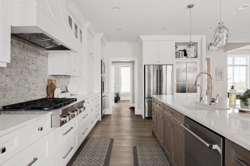 Kitchen view showcasing white cabinetry, gas stove, and island in Pleasant Grove custom home by Conner Construction Company