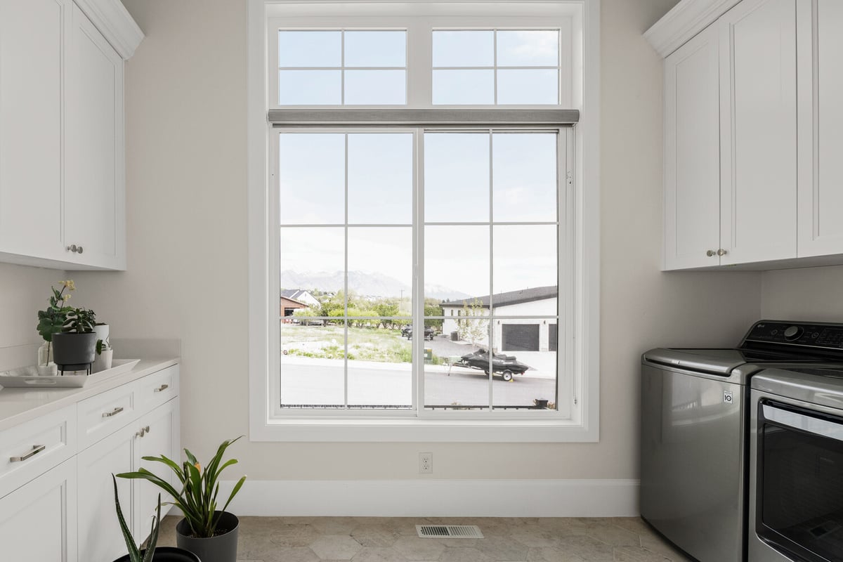 Laundry room with white cabinets and mountain views in custom home by Conner Construction Company in Pleasant Grove, UT