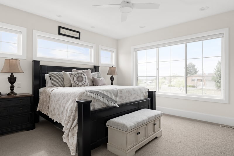 Serene primary bedroom with large windows and black bedframe in custom home by Conner Construction in Pleasant Grove, UT