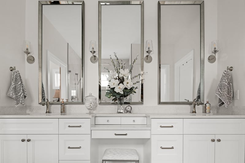 Triple vanity setup with framed mirrors and quartz counters in Pleasant Grove custom home by Conner Construction Company