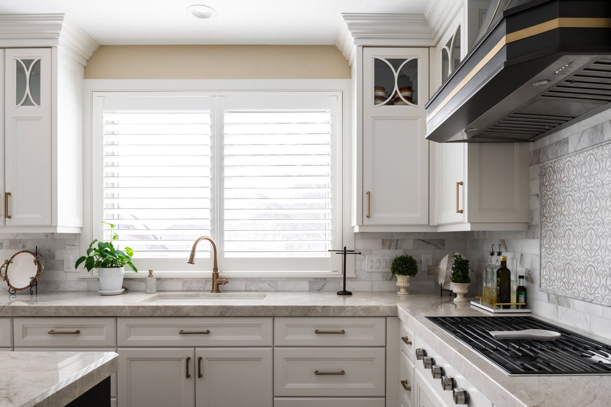 Kitchen sink and range view with marble countertops in Highland, UT custom home by Conner Construction Company