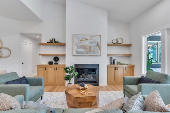Cozy open-concept living room with custom shelving and fireplace design in a Utah County home by Conner Construction Company
