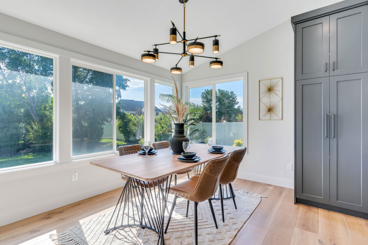 Bright dining nook with modern chandelier and large windows in a custom home by Conner Construction Company in Eagle Mountain