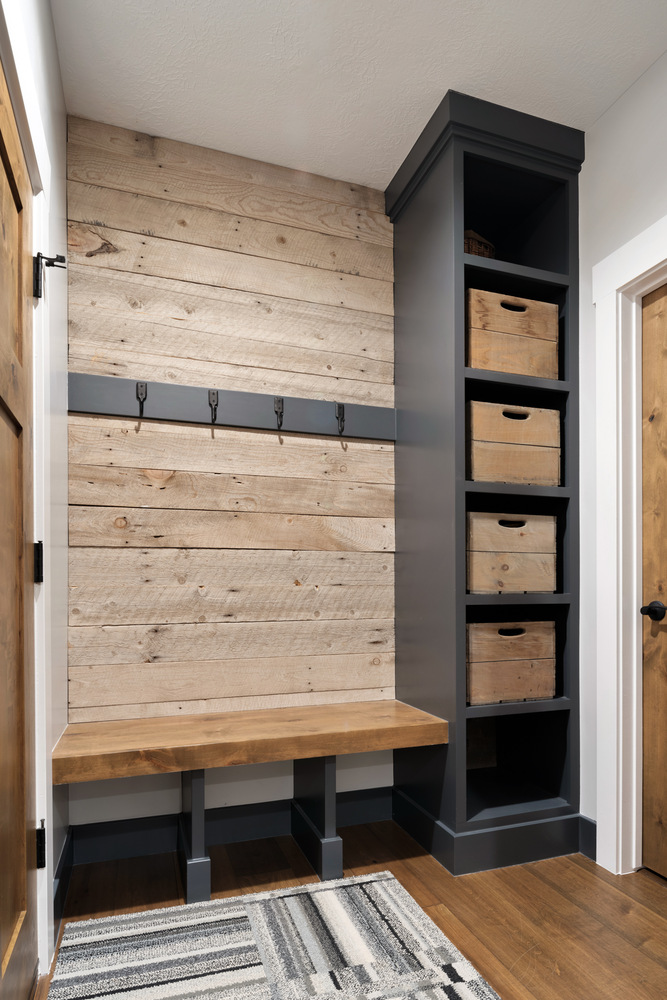 Mudroom design with reclaimed wood accents and black built-in shelving by Conner Construction Company in Utah County