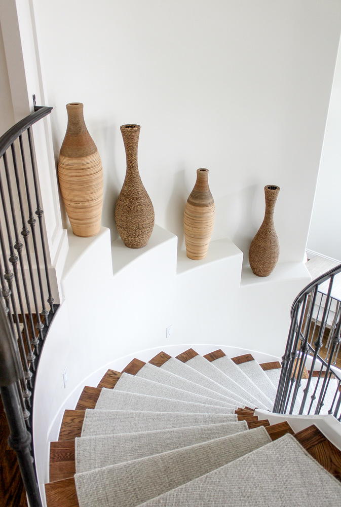 Spiral staircase with woven vases and iron railings in a custom home by Conner Construction Company in Draper, UT