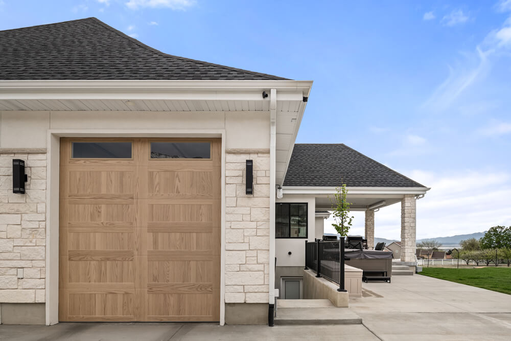 Large garage door with patio and furniture, Utah Custom Home Builders: Exterior.