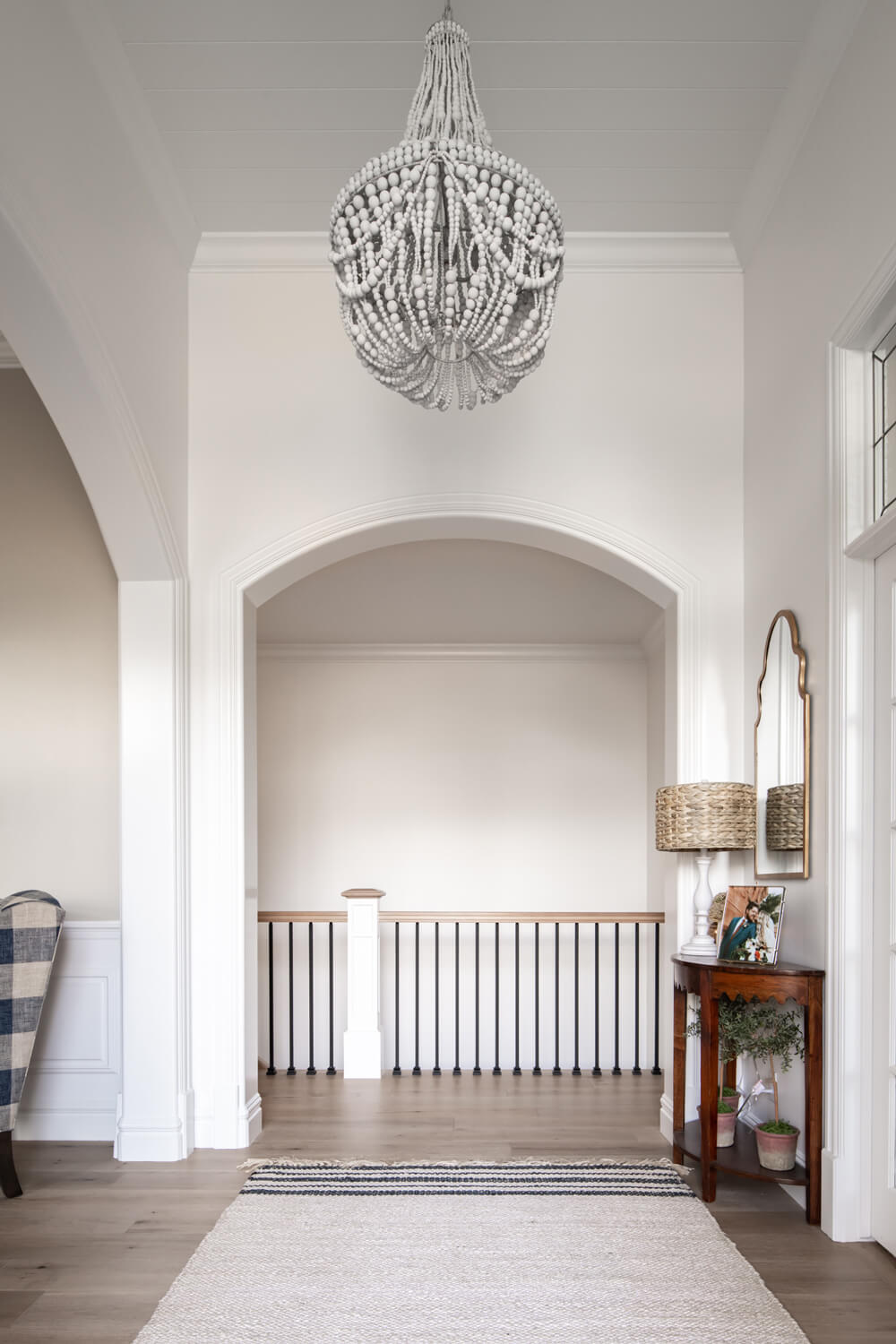 Stylish white foyer with chandelier and rug at Utah Home Builders