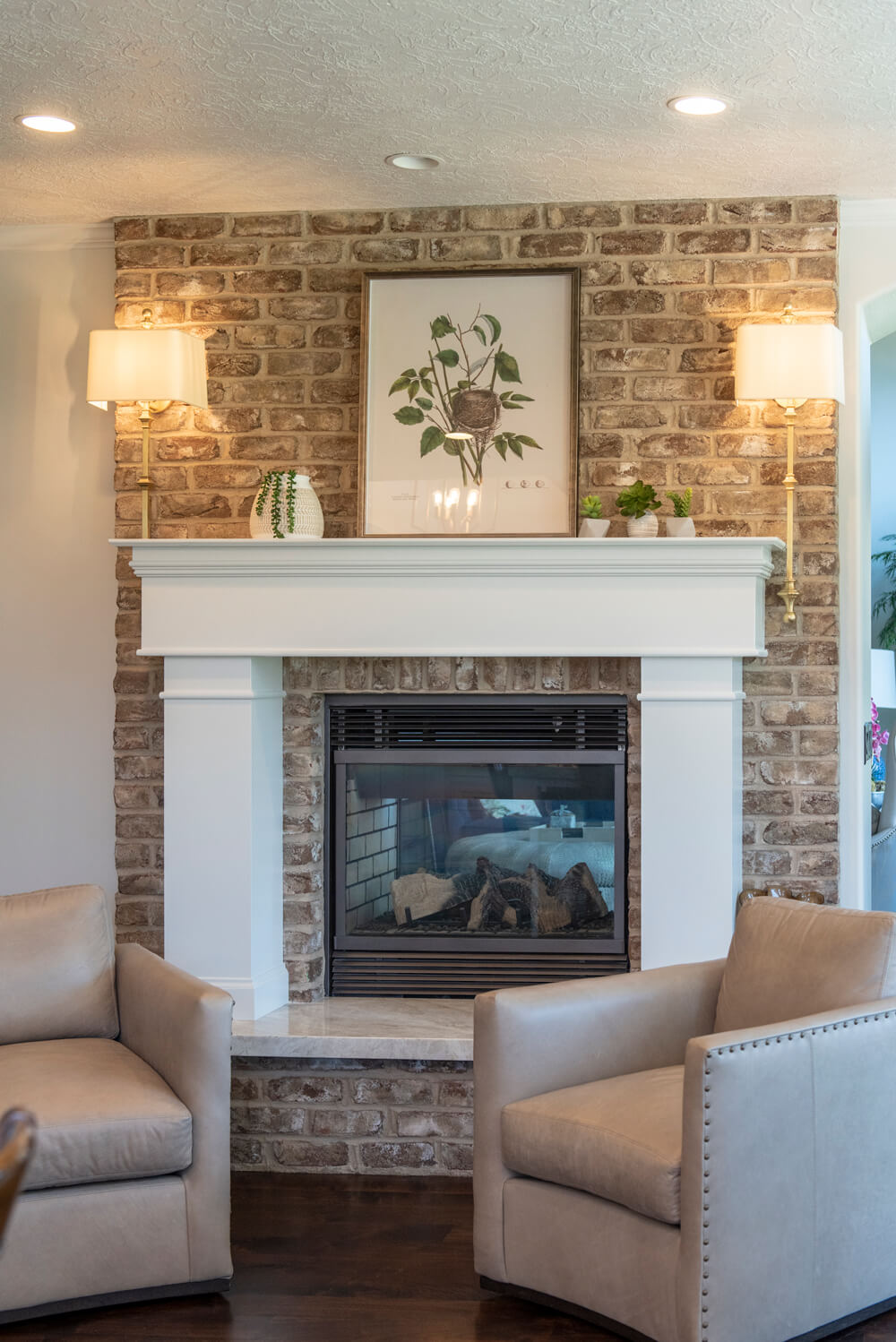 A cozy living room with a fireplace and two chairs, Utah Custom Home Builders.