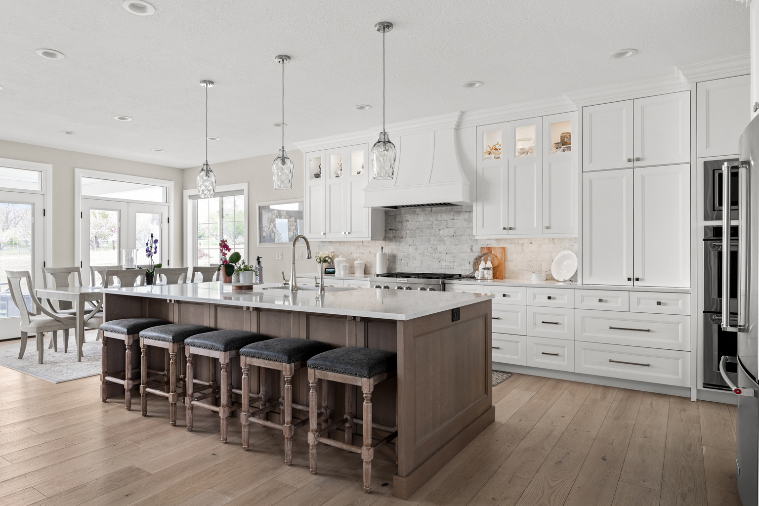 A kitchen with white cabinets and wooden floors. Utah Home Builders Kitchen.