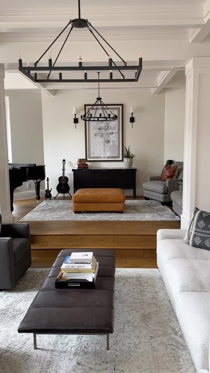 A spacious living room with elegant chandelier and comfortable couches