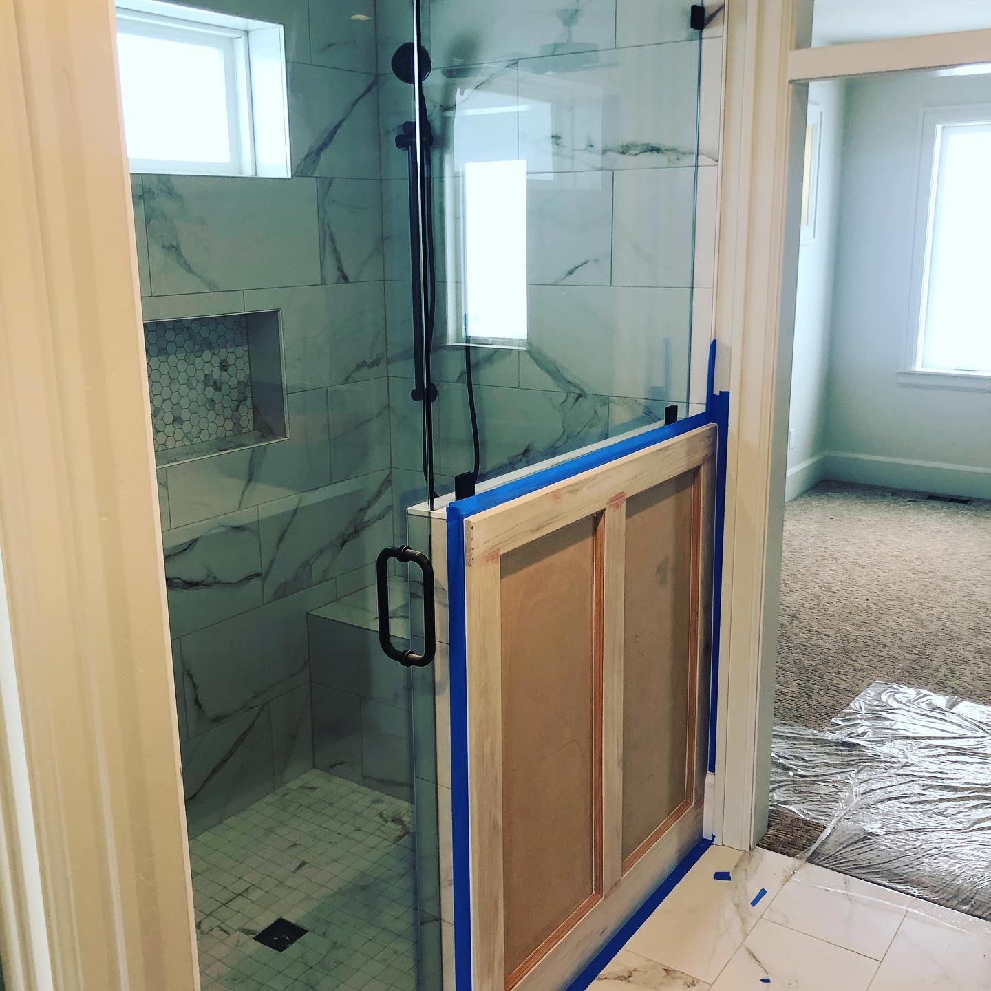 A shower door with a blue tape on it